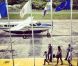 Laeticia Hallyday prend une photo de l'aéroport de Saint-Barthélémy, d'où elle aperçoit son mari Johnny Hallyday en train de débarquer de l'avion avec Yarol Poupaud et Caroline de Maigret, en famille. Août 2012