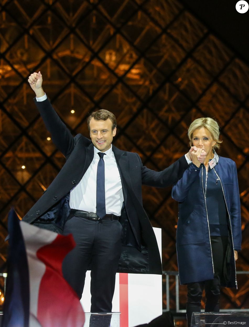 Emmanuel Macron, élu président de la république, et sa femme Brigitte Macron (Trogneux), saluent les militants devant la pyramide au musée du Louvre à Paris, après sa victoire lors du deuxième tour de l'élection présidentielle. Le 7 mai 2017.