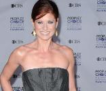 Debra Messing en robe boule bustier gris sombre a su mettre en valeur son roux flamboyant  