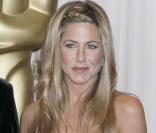 Jennifer Aniston, radieuse à la soirée des Oscars, garde les bras le long du corps... pour éviter que la robe ne tombe ! 