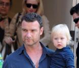 Naomi Watts (en arrière-plan) et Liev Schreiber portant leur fils aîné Alexander sortant de leur appartement à New York le 10 juillet 2009