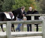 Sophie Tapie, Giovanni Castaldi et Jean-Pierre s'occupent de la monture de Paola pendant que cette dernière fait sa reconnaissance du parcours de saut d'obstacles. 