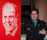 L'artiste Marcos Marin devant un portrait du prince Albert  lors de la soirée de ventes aux enchères à l'hôtel Méridien de Monte-Carlo le 1er décembre, au profit de l'association Fight Aids Monaco