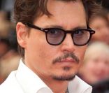 Johnny Depp lors de la projection de Pirates des Caraïbes, La Fontaine de Jouvence, le samedi 14 mai 2011. L\'acteur s\'est coupé les cheveux et arbore un costume élégant noir et blanc !<br />