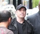 John Travolta, entouré de gardes du corps, s'apprête à entrer dans le restaurant asiatique Dave à Paris le 20 juin 2011