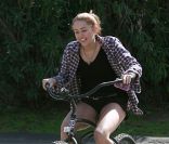 Miley Cyrus à velo, morte de rire avec ses bottes 