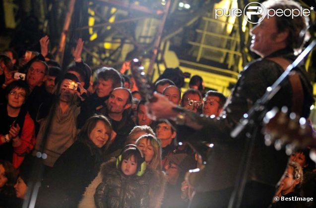 Johnny Hallyday lors de son concert à la tour Eiffel, le 3 décembre 2011. Nathalie Baye est au premier rang.