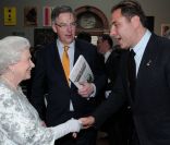 Le comédien David Walliams serre la main de la reine Elizabeth II, qui avait rendez-vous avec des centaines de personnalités britanniques majeures du monde des arts, le 23 mai 2012 à la Royal Academy of Arts de Londres, dans le cadre de son jubilé de