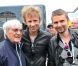 Matthew Bellamy et Dominic Howard accompagnent Bernie Ecclestone dans le paddock du Grand Prix de Formule 1 de Grande Bretagne à Silverstone le 8 juillet 2012
