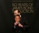 Sir Roger Moore s'éclate avec un masque de Daniel Craig ! Vente aux enchères d'objets de la saga James Bond donnés par les acteurs de la franchise, chez Christie's, à Londres, le 5 octobre 2012