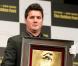 Le pied gauche de Lionel Messi immortalisé dans l'or et présenté le 6 mars 2013 à Tokyo par son frère, souriant