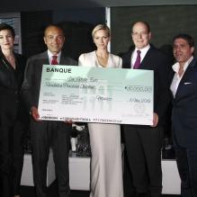 <p>La princesse Charlene de Monaco recevant un don pour sa fondation à la soirée d'inauguration du club privé Italian Luxury Club au Zelos, au Forum Grimaldi, le 10 mai 2013.</p>