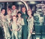Une photo de la série Lost in Space (1965), à droite le robot joué par Bob May