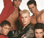 Les Take That au grand complet dans les années 90. De gauche à droite : Mark Owen, Jason Orange, Gary Barlow, Howard Donald et Robbie Williams. 