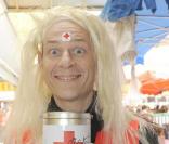 Alain Bouzigues a remplacé sa machine à café par un tirelire la Croix-Rouge. Mais en blonde, il ne doit pas faire la différence ! Après ses t-shirts aussi moulants que fluos, porter la perruque blonde pour Alain, c'est un jeu d'enfant !  