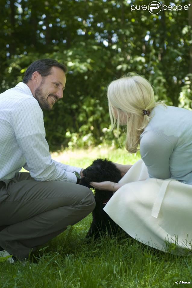 La famille princière de Norvège avec leur nouveau chien Milly Kakao le 28 juin 2009 à Oslo : le prince Haakon et Mette-Marit 