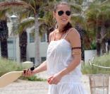 Qui souhaite partager une partie de raquettes de plage avec Elsa Pataky ? Avant le jeu, la belle a pris soin de revêtir une légère robe blanche pour éviter les coups de soleil. 