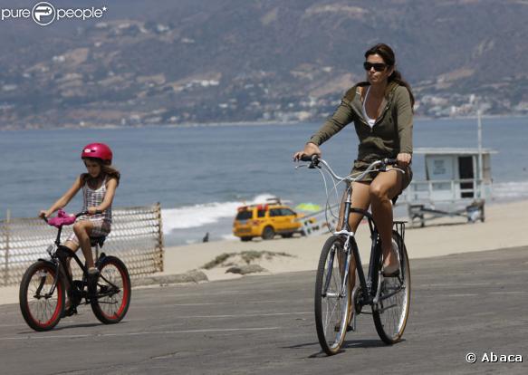 Cindy Crawford est une maman très attentionnée. Lorsqu'elle emmène sa petite Kaya, en promenade à vélo au bord de l'eau, elle pense à lui mettre son casque et surveille la circulation.