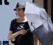 Quand Famke Janssen se cache sous son parapluie pour masquer son look discutable... Grillée !
