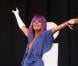 Le 26 juin 2009, Lily Allen montre toute sa folie lors du Festival de Glastonbury. Combinaison bleue tachetée, perruque mauve et gant blanc, la chanteuse enchante son public. 