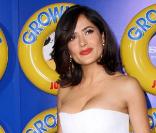Salma Hayek, sublime dans une superbe robe bustier en toile de coton blanc, portée avec une ceinture en cuir rouge de la collection Croisière 2011, sans oublier ses escarpins en cuir également rouge, le tout signé Yves Saint Laurent.