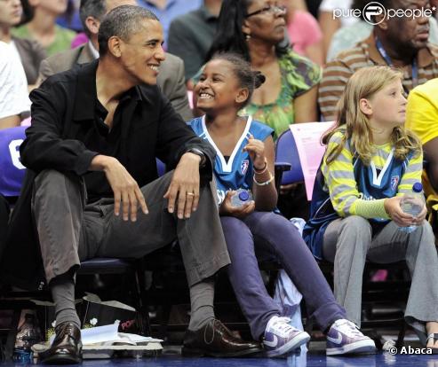 Barack Obama assiste à un match de basket féminin, le 1er août 2010. Sa fille Sasha est à ses côtés.  