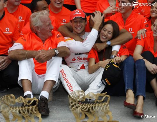 Avec tout le Team Mc Laren, Lewis Hamilton se réjouit et félicite son compatriote et coéquipier Jenson Button, entouré de son père John et sa chérie Jessica Michibata. 
 Dimanche 31 juillet 2011, Jenson Button remportait le 11e Grand Prix de sa carrière en Hongrie, sur le Hungaroring, pour son 200e départ en F1.
