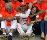  Avec tout le Team Mc Laren, Lewis Hamilton se réjouit et félicite son compatriote et coéquipier Jenson Button, entouré de son père John et sa chérie Jessica Michibata. 
 Dimanche 31 juillet 2011, Jenson Button remportait le 11e Grand Prix de sa carrière en Hongrie, sur le Hungaroring, pour son 200e départ en F1. 