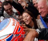  Jessica Michibata et john Button félicitent leur héros, Jenson Button, à l'arrivée du Grand Prix de Hongrie. 
 Dimanche 31 juillet 2011, Jenson Button remportait le 11e Grand Prix de sa carrière en Hongrie, sur le Hungaroring, pour son 200e départ en F1. 