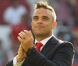 Robbie Williams en costume sur la pelouse d'Old Trafford avant le coup d'envoi. Manchester, le 27 mai 2012.