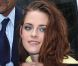 Kristen Stewart, souriante en quittant le défilé Balenciaga. Paris, le 27 septembre 2012.