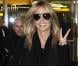 Heidi Klum, souriante, lance un "Deuces" aux photographes à son arrivée à l'aéroport d'Heathrow. Londres, le 16 Octobre 2012.