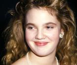 Drew Barrymore il y a de nombreuses années, avec un peu plus de poids et de longs cheveux blond cendré  