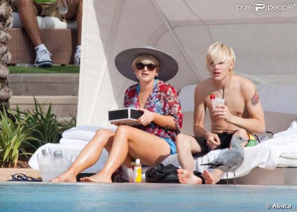 Repos au bord de la piscine pour Kelly Osbourne et Luke Worrall, avant d'être surpris par la présence d'une tornade au large. À Miami, le 14 décembre 2009.