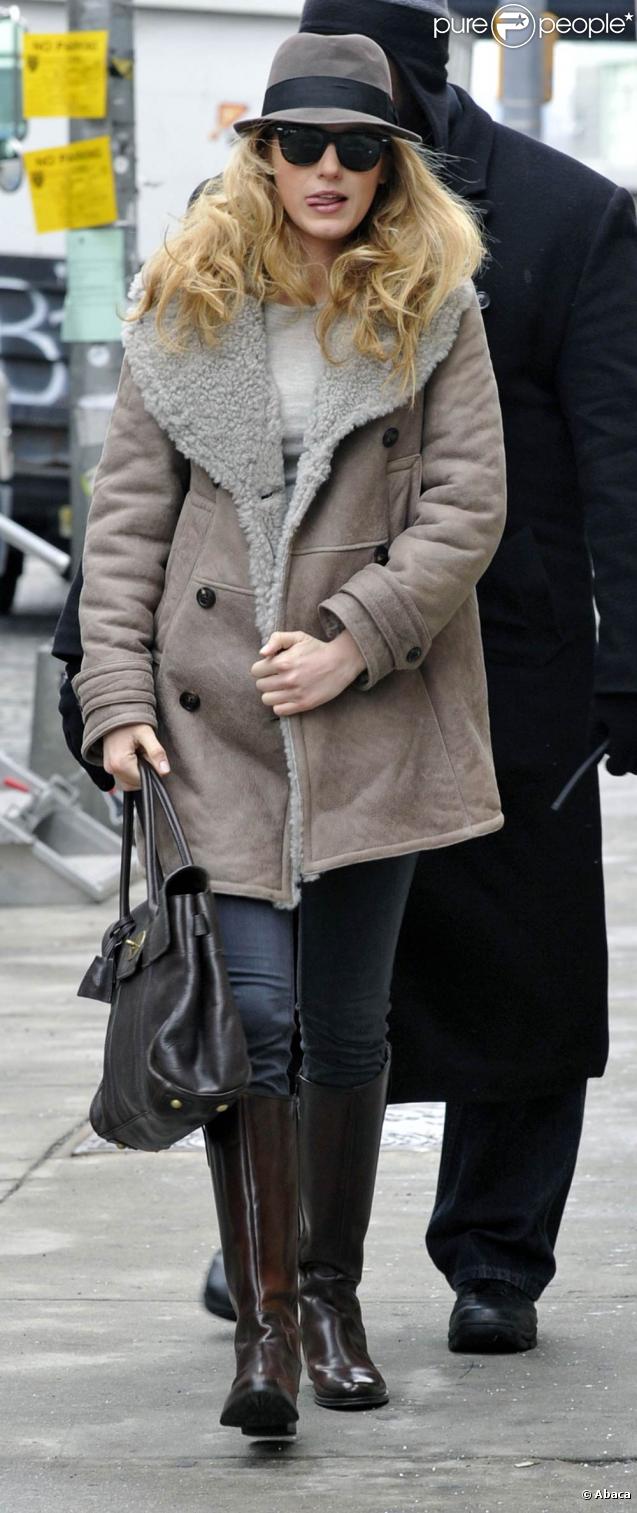 Blake Lively dans un look city-chic, enveloppée dans une manteau Burberry et jamais sans son chapeau et son sac Saint Laurent 