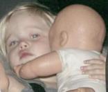 Avec sa poupée, la petite fille est trop mignonne.  