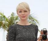 Michelle Williams juchée sur des sandales Stella McCartney, et joliment habillée d'une mini robe boule de chez Suno.