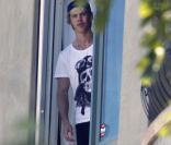 Austin Butler tente d'échapper aux paparazzi en sortant du domicile de sa chérie, Vanessa Hudgens, lundi 19 septembre 2011, à Los Angeles.