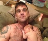 Première photo de la petite Teddy avec son papa Robbie Williams, postée sur le site officiel du chanteur, le 20 septembre 2012.
