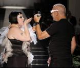 Beth Ditto et Jean Paul Gaultier trinquent lors du défilé prêt-à-porter printemps-été 2013 du créateur français.