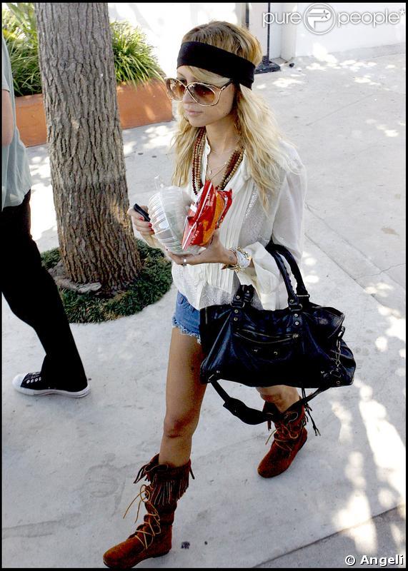 Bottes à franges, colliers de perles en bois, grosses lunettes et bandeau dans les cheveux... Son petit short sexy passerait presque inaperçu !