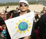 Pascal Obispo brandit le drapeau qui a rallié la foule de participants à l'occasion de la Journée Mondiale de la Terre 