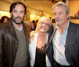 Anthony et Alain Delon entourent Dominique Todt, directrice des RP de Tod's Farnce, à la soirée donnée le 28 avril 2009, rue du Faubourg St Honoré.