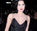 Dita Von Teese dans une longue robe satinée. Un noir qui met en valeur sa belle crinière...<br />