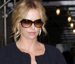 Charlize Theron en mode casual avec une robe noire, simple, associée à des spartiates  