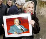 Joséphine Dard portant un portrait de son père lors de l'inauguration du jardin Frédéric Dard le 16 décembre 2010 sur la Butte Montmartre à Paris
