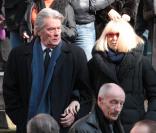 Alain Delon et Mireille Darc quittant l'église Saint-Roch à Paris où se sont déroulées les obsèques d'Annie Girardot le 4 mars 2011