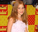 Emma Watson affiche sa mine timide et tente d'être féminine dans sa ravissante robe blanche. Londres, 3 novembre 2002 