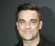 Robbie Williams, sobre et élégant, provoque la folie