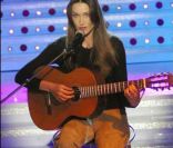Lorsque Carla Bruni pousse la chansonnette avec sa guitare, son look ne compte plus. L\'artiste opte pour un pantalon camel et un top noir... Rien de plus simple ! 7 mars 2003<br />